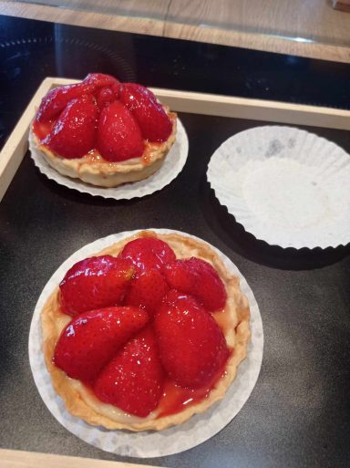 Des tartelettes aux fraises dans une boîte en bois